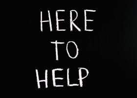 White text 'Here to Help' on a minimalist black chalkboard background, conveying encouragement and support.